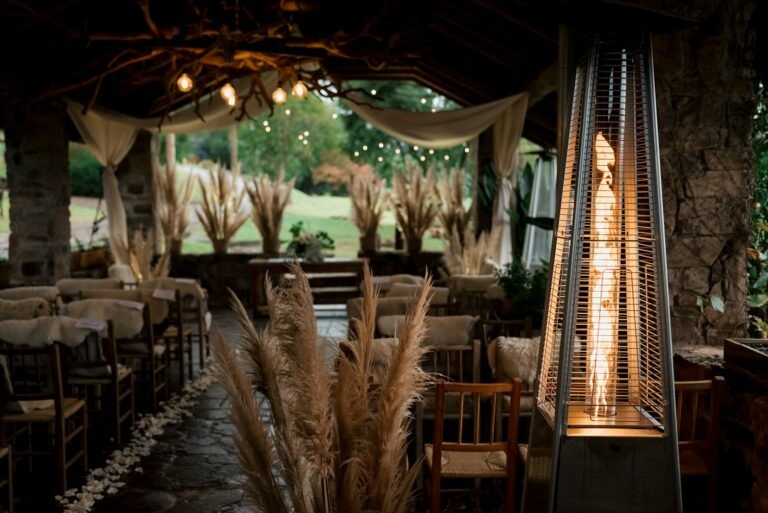 Glowing patio heater beside chairs at an evening outdoor event with string lights