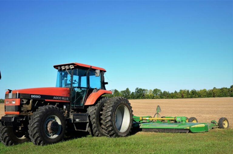 Tractor pulling a grass topper across a mown field
