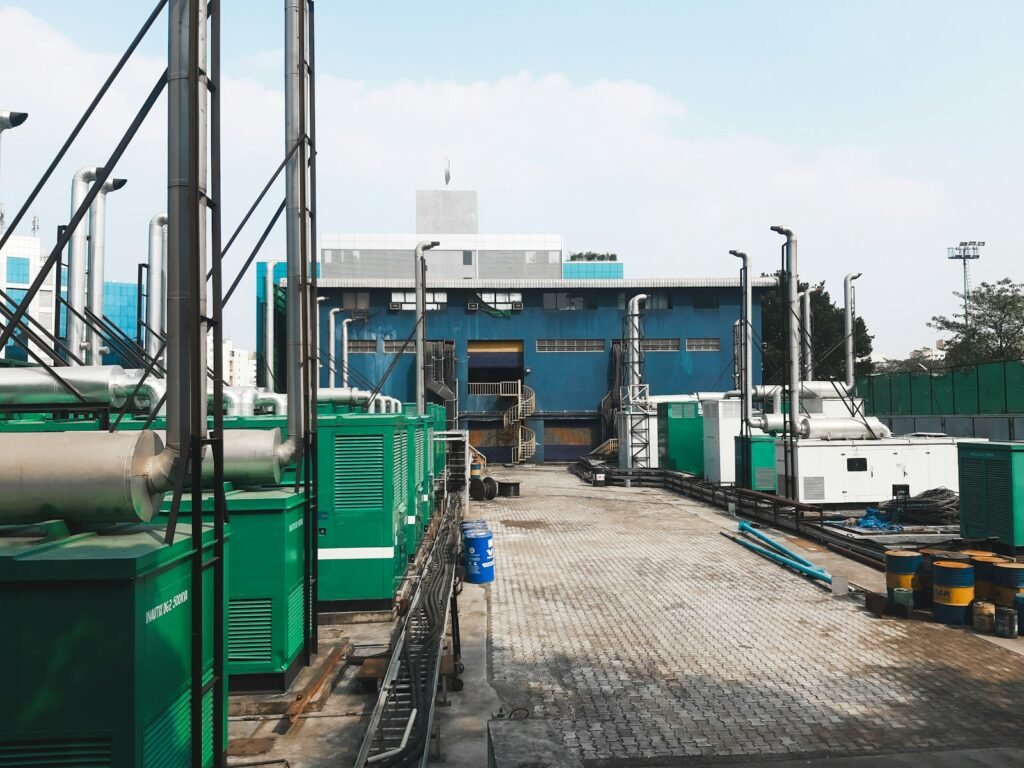 Row of green containerised diesel generator sets on an industrial site