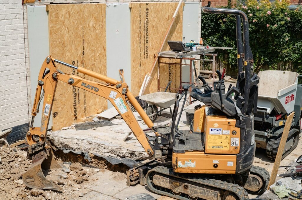 Micro excavator digging beside a house extension on a tight residential building site