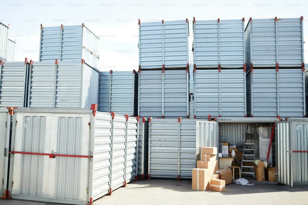 Stacked steel storage containers with boxes inside an open unit