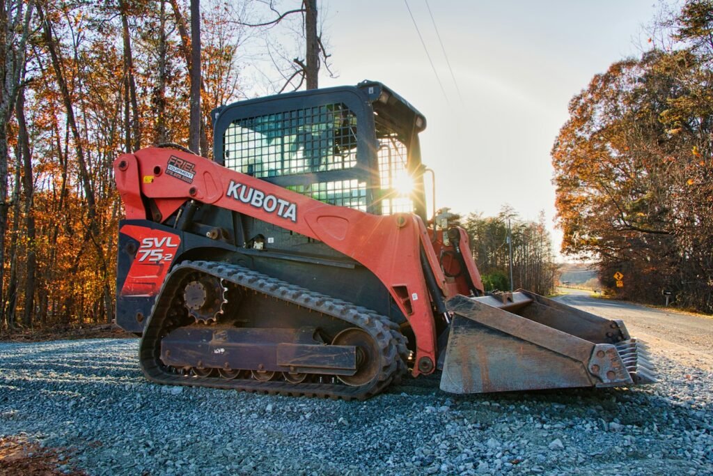 Compact track loader on a compacted gravel base, the kind of MOT Type 1 sub base this guide covers