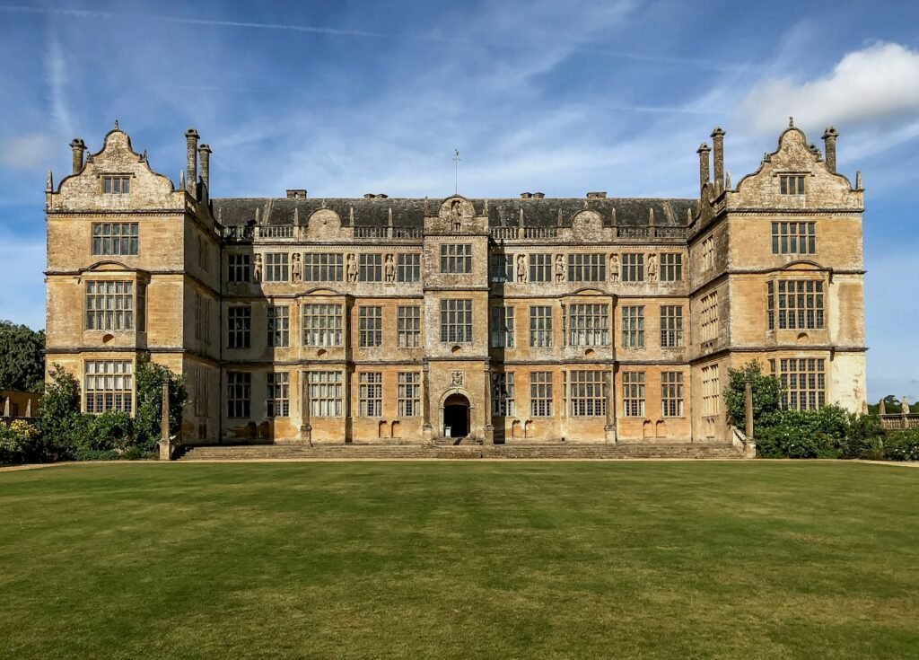 Honey-coloured Ham stone facade of Montacute House near Yeovil behind a broad lawn
