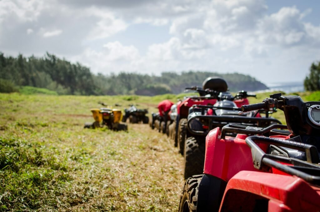 Row of quad bikes parked on a grassy hillside field